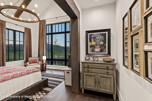 bedroom featuring multiple windows, a chandelier, vaulted ceiling, and dark wood-type flooring