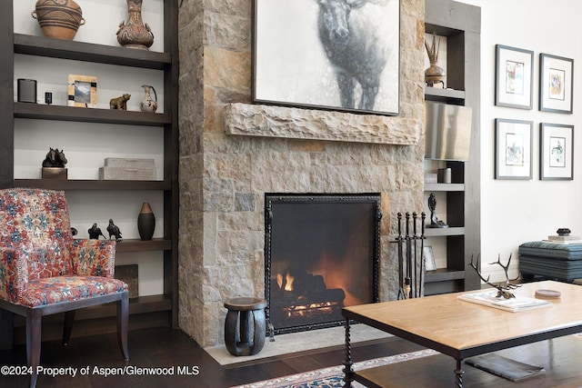 living room with a fireplace with flush hearth and built in shelves