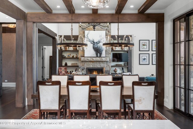 bar featuring a notable chandelier, a fireplace, dark wood finished floors, and beam ceiling