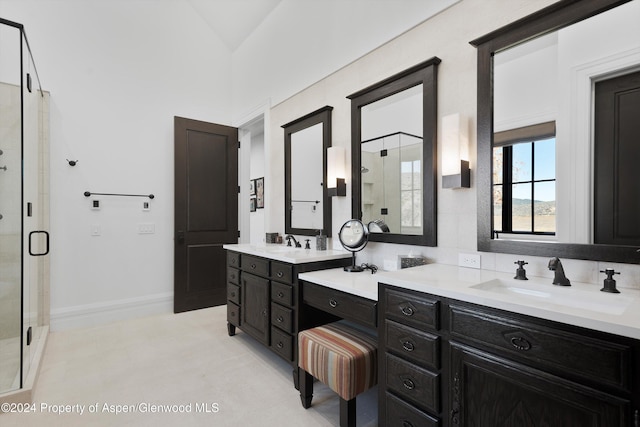 full bath featuring a stall shower, vanity, and baseboards