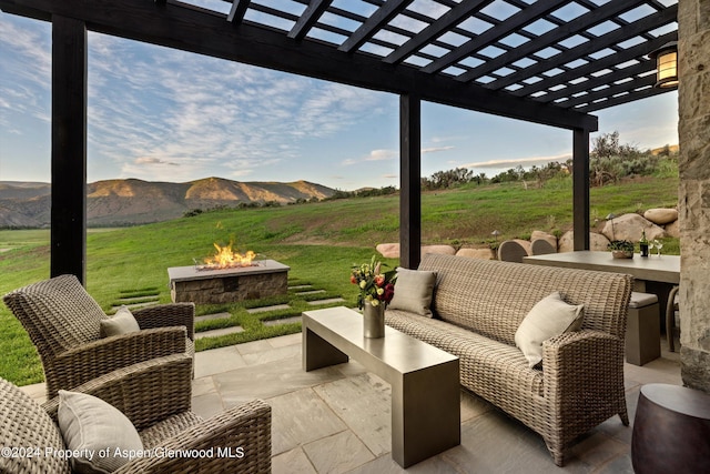 view of patio featuring an outdoor living space with a fire pit, a mountain view, a pergola, and a rural view