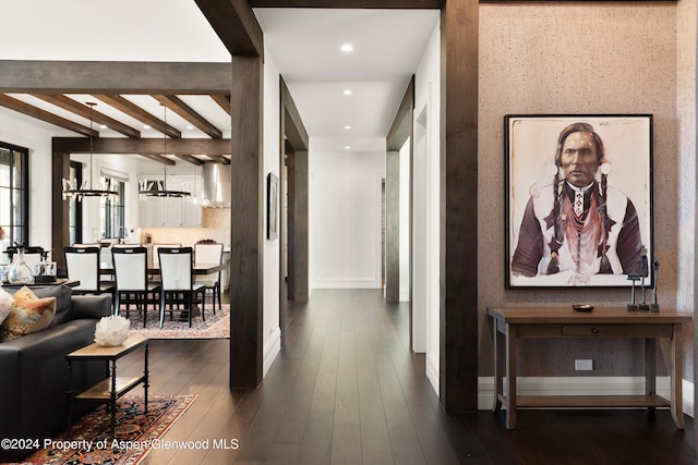 hallway featuring recessed lighting, dark wood-type flooring, a chandelier, beamed ceiling, and baseboards