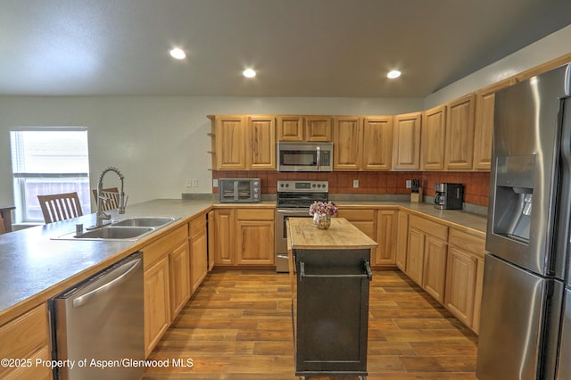 kitchen with sink, light hardwood / wood-style flooring, wooden counters, stainless steel appliances, and kitchen peninsula