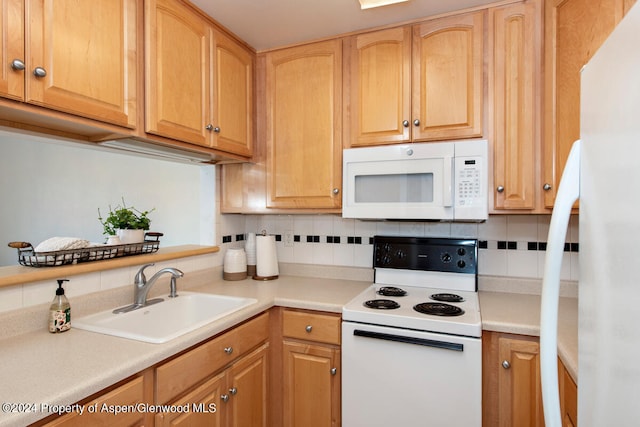 kitchen with a sink, decorative backsplash, white appliances, and light countertops