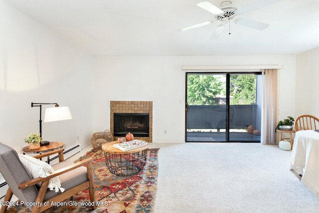 carpeted living area featuring a tile fireplace, a baseboard heating unit, and a ceiling fan