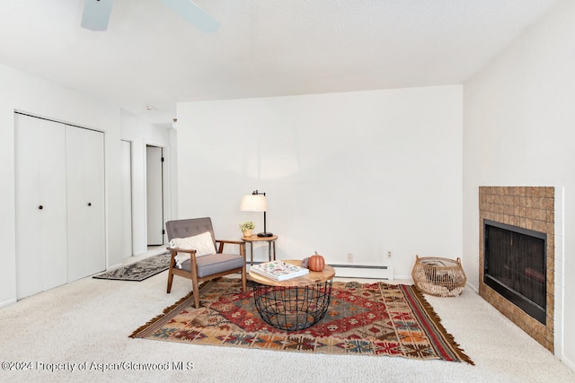 living area with a baseboard radiator and a tiled fireplace