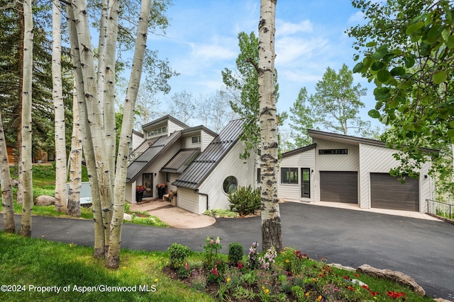 177 Stellar Ln, Snowmass Village, CO 81615 - view of front of home featuring asphalt driveway, a garage, and a metal roof