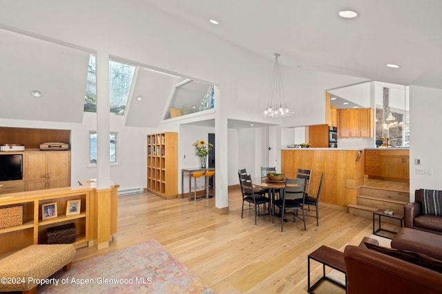 living room featuring a notable chandelier, baseboard heating, high vaulted ceiling, and light hardwood / wood-style flooring