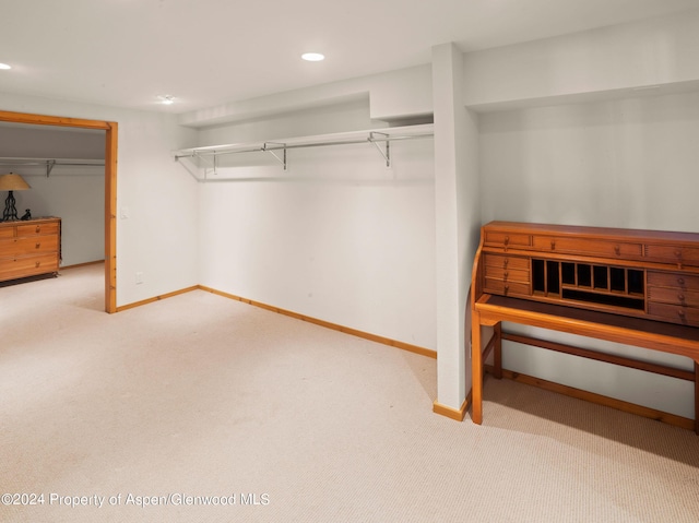 walk in closet featuring light carpet