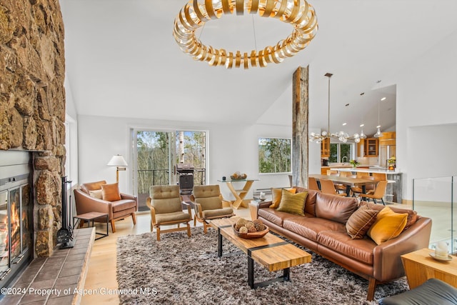 177 Stellar Ln, Snowmass Village, CO 81615 - living area with high vaulted ceiling, light wood-style flooring, a chandelier, and a stone fireplace