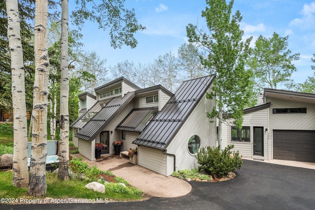 177 Stellar Ln, Snowmass Village, CO 81615 - mid-century home with a standing seam roof, driveway, a metal roof, and a garage