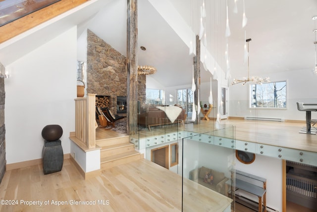 interior space featuring a fireplace, a baseboard radiator, hardwood / wood-style flooring, and a notable chandelier