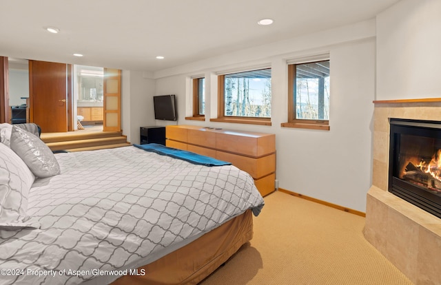 carpeted bedroom featuring a fireplace