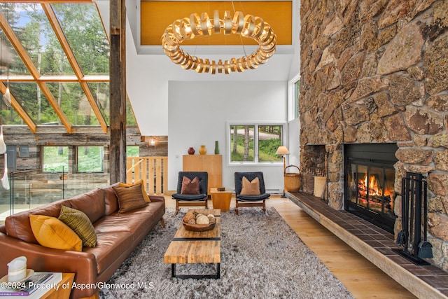 177 Stellar Ln, Snowmass Village, CO 81615 - living area with a stone fireplace, wood finished floors, a high ceiling, and a baseboard heating unit