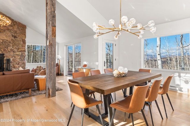 dining area with a wealth of natural light, a notable chandelier, lofted ceiling, and light wood-type flooring