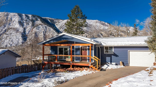 view of front of property featuring a garage, covered porch, and a mountain view