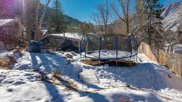 yard covered in snow with a trampoline