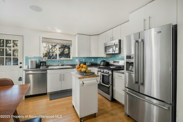 kitchen featuring sink, a center island, white cabinetry, and appliances with stainless steel finishes