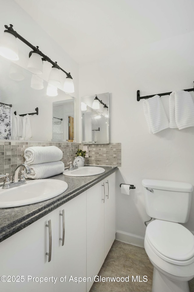 bathroom featuring toilet, tile patterned flooring, tasteful backsplash, and vanity