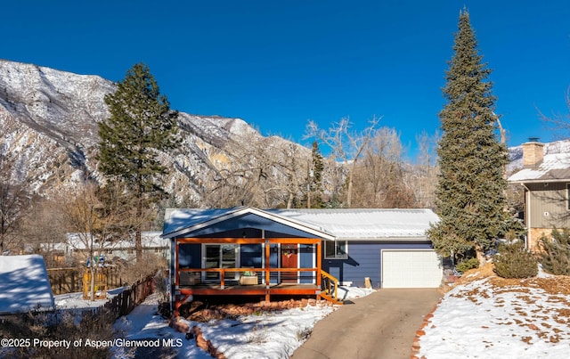 view of front of house featuring a garage, covered porch, and a mountain view