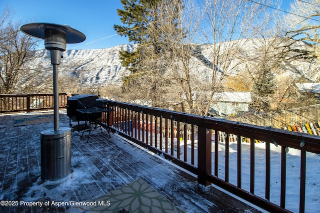 snow covered deck featuring a mountain view