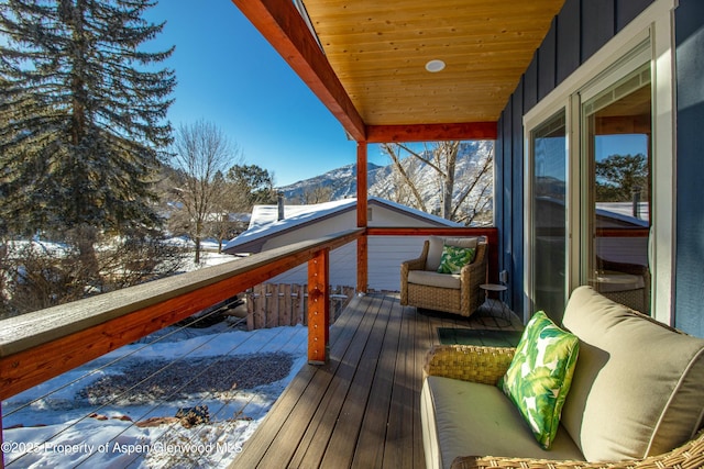 snow covered deck with a mountain view