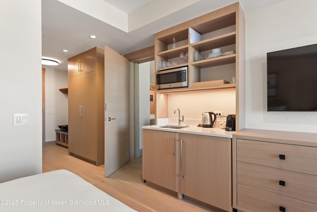 130 Wood Rd Unit 660-662, Snowmass Village, CO 81615 - kitchen with stainless steel microwave, light wood-type flooring, open shelves, light countertops, and light brown cabinetry