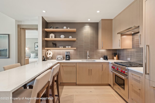 130 Wood Rd Unit 660-662, Snowmass Village, CO 81615 - kitchen featuring designer range, under cabinet range hood, light brown cabinets, light wood-type flooring, and backsplash