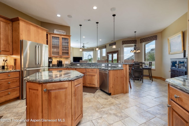 759 36 3/10 Rd, Palisade, CO 81526 - kitchen with stainless steel appliances, a peninsula, brown cabinets, tasteful backsplash, and recessed lighting