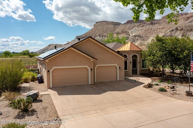 759 36 3/10 Rd, Palisade, CO 81526 - view of front of property featuring stucco siding, a garage, driveway, and a mountain view