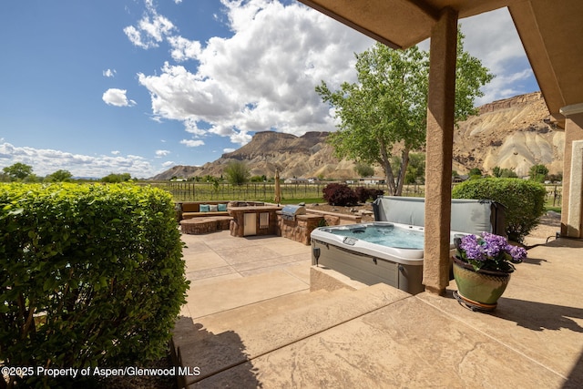 759 36 3/10 Rd, Palisade, CO 81526 - view of patio featuring a hot tub, a mountain view, fence, and a fire pit