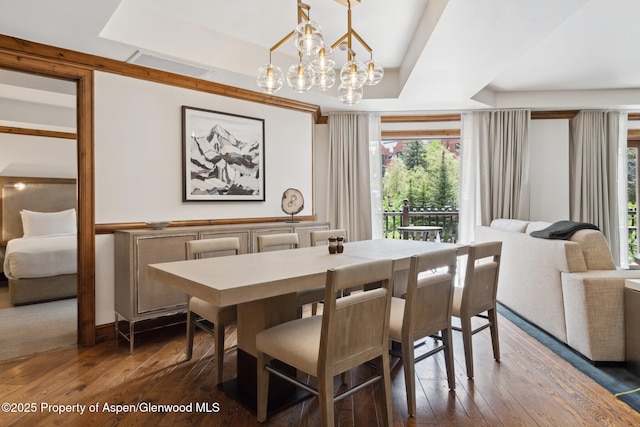 dining room featuring a notable chandelier, dark hardwood / wood-style flooring, and a tray ceiling