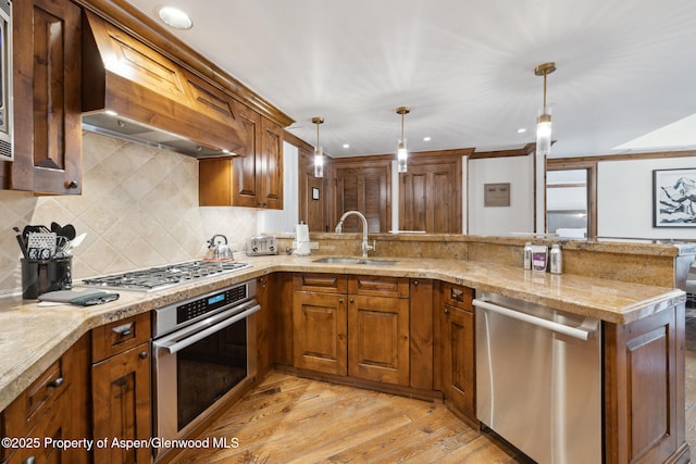 kitchen featuring premium range hood, sink, kitchen peninsula, pendant lighting, and stainless steel appliances