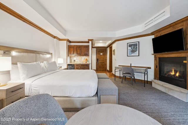 carpeted bedroom featuring a raised ceiling