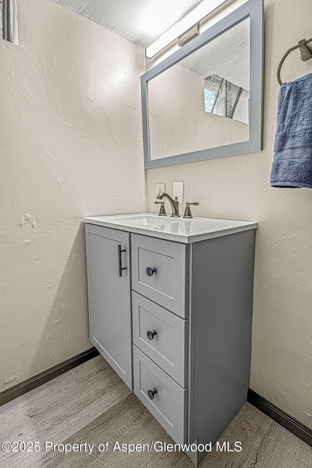 828 Taylor St, Craig, CO 81625 - bathroom featuring wood finished floors, vanity, and a textured wall