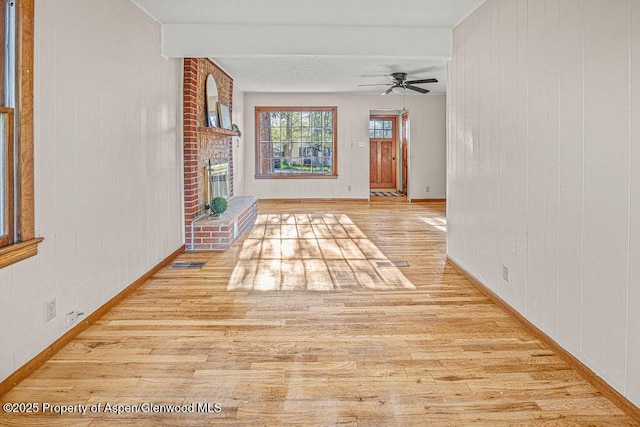 828 Taylor St, Craig, CO 81625 - unfurnished living room featuring wood finished floors, a ceiling fan, baseboards, a fireplace, and wooden walls