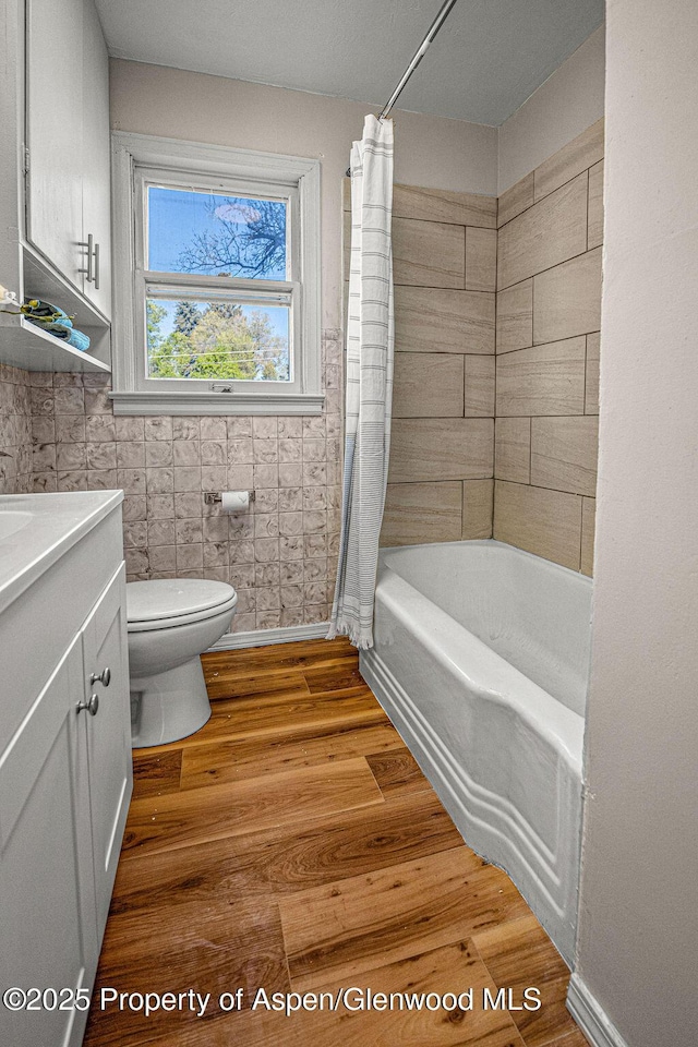 828 Taylor St, Craig, CO 81625 - bathroom featuring toilet, vanity, wood finished floors, and shower / bathtub combination with curtain