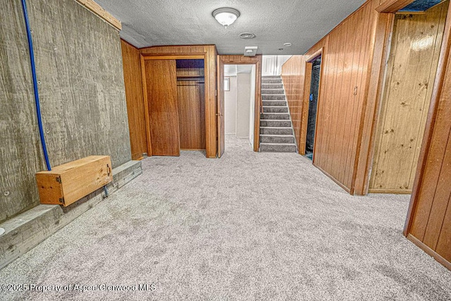 828 Taylor St, Craig, CO 81625 - unfurnished bedroom featuring carpet, wooden walls, and a textured ceiling