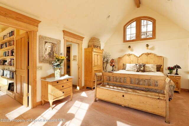 carpeted bedroom featuring beamed ceiling and high vaulted ceiling