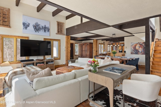 0184 Mountain Laurel Dr, Aspen, CO 81611 - living room with beamed ceiling, wood-type flooring, and an inviting chandelier