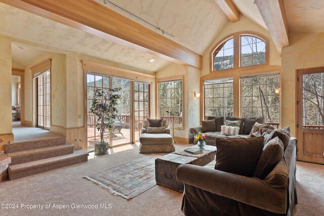 living room with vaulted ceiling with beams and light carpet