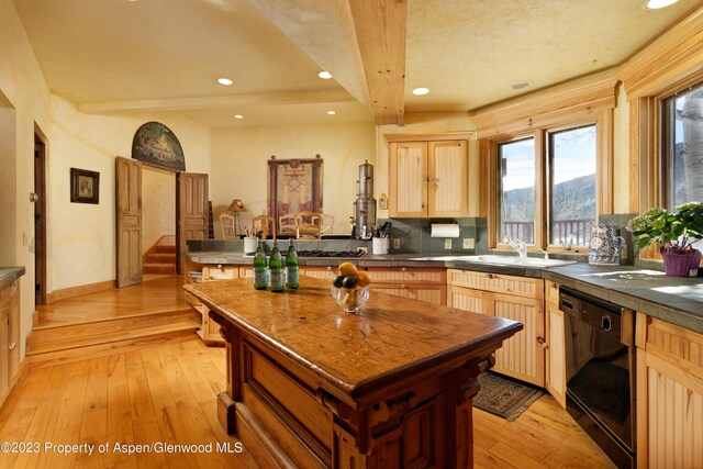 kitchen with dishwasher, sink, light hardwood / wood-style flooring, a mountain view, and light brown cabinetry