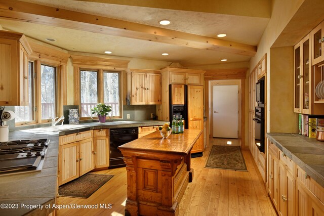 kitchen with black appliances, light hardwood / wood-style floors, beam ceiling, and light brown cabinetry