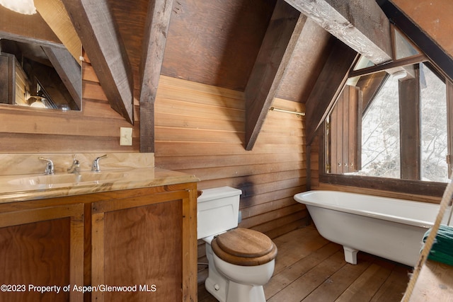0184 Mountain Laurel Dr, Aspen, CO 81611 - bathroom with wood walls, a bathing tub, sink, hardwood / wood-style flooring, and toilet
