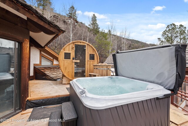 view of patio featuring a deck with mountain view and a hot tub