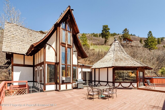 exterior space with a gazebo, a wooden deck, and a hot tub