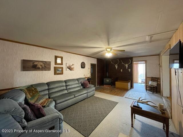 84 Veatch Ave, Maybell, CO 81640 - carpeted living room with a wood stove and ceiling fan