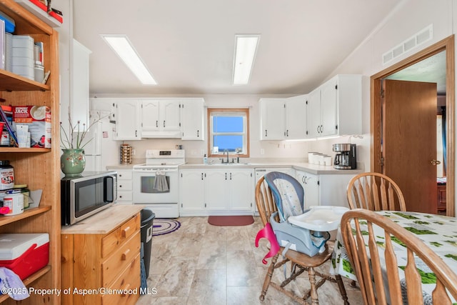 400 Behrman St, Craig, CO 81625 - kitchen featuring white electric range, stainless steel microwave, under cabinet range hood, light countertops, and white cabinets