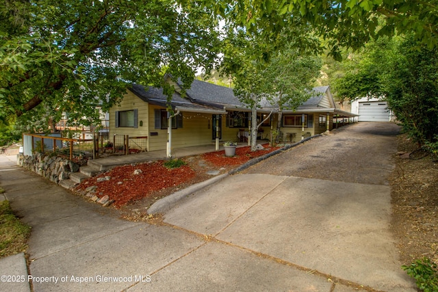 1026 Palmer Ave, Glenwood Springs, CO 81601 - ranch-style house featuring covered porch, a shingled roof, an outbuilding, and driveway