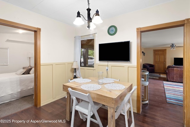 1026 Palmer Ave, Glenwood Springs, CO 81601 - dining area with dark wood-style flooring, a chandelier, wainscoting, ceiling fan, and a decorative wall